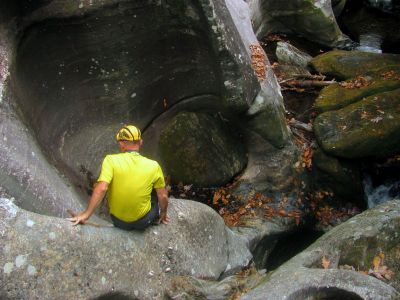 John makes his way carefully down the blockage fish rock to get back to the bottom of the slot canyon 
