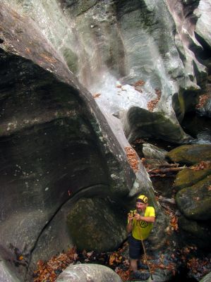 John makes his way carefully down the blockage fish rock to get back to the bottom of the slot canyon 
