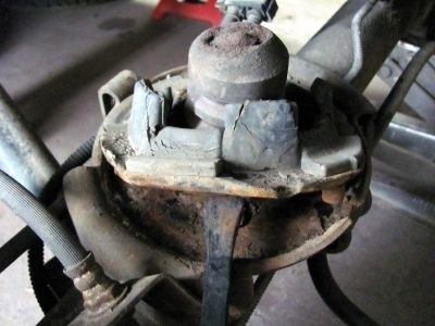 removing the lower coil sporing isolator from rear coil . Rusted but nowhere near as bad as front. Cleaned and sanded well and painted with POR. 
