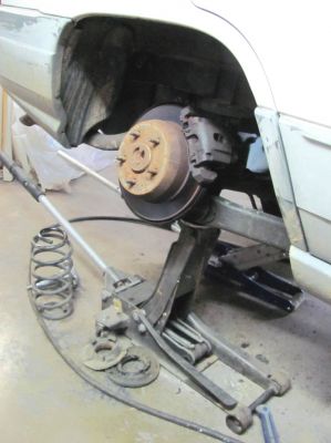 Jacking up one side as far as it will go to give room to get the coil back in with new rubbers and the spacer. 
