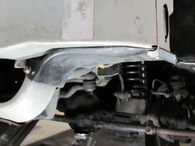 View of the inner fender folded around and bolted to the lower part of the metal inner bumper
