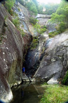 Tyler in a box canyon at the base of a large waterfall in NC 
