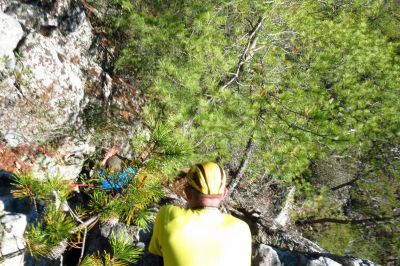 Tyler on his first descent of  the crack using the rope and harness he rigged up as John looks on with much interest  (Taken with my larger camera) 
