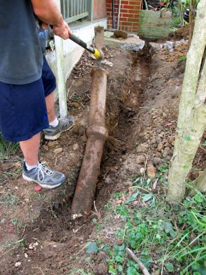 Tyler digging out the old clay gutter drain pipe. 
